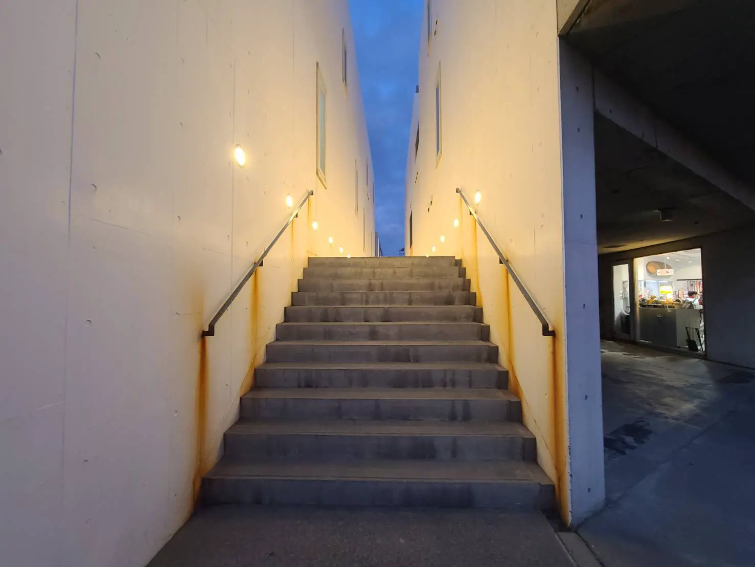 照明が設置されたコンクリートの階段、夕方の都市風景