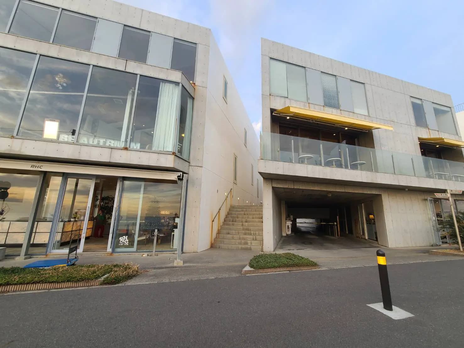 モダンな外観のビル、コンクリートのファサード、大きなガラス窓が特徴的な建築デザイン