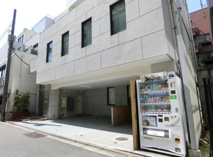都会のアパートの外観、自動販売機と木製のパネルがあるモダンな入り口
