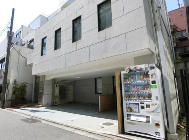都会のアパートの外観、自動販売機と木製のパネルがあるモダンな入り口