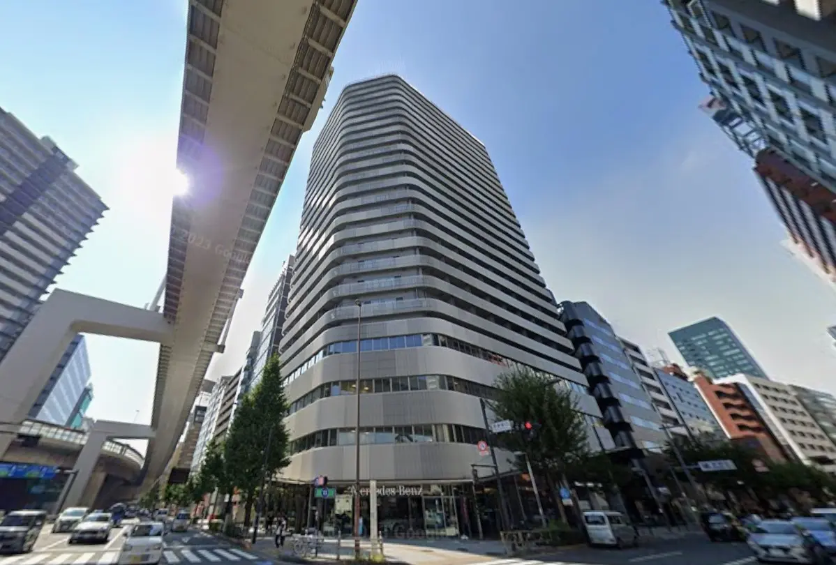 日差しが差し込む都市風景、高架下と近代的なビル群、清潔感のある街並み