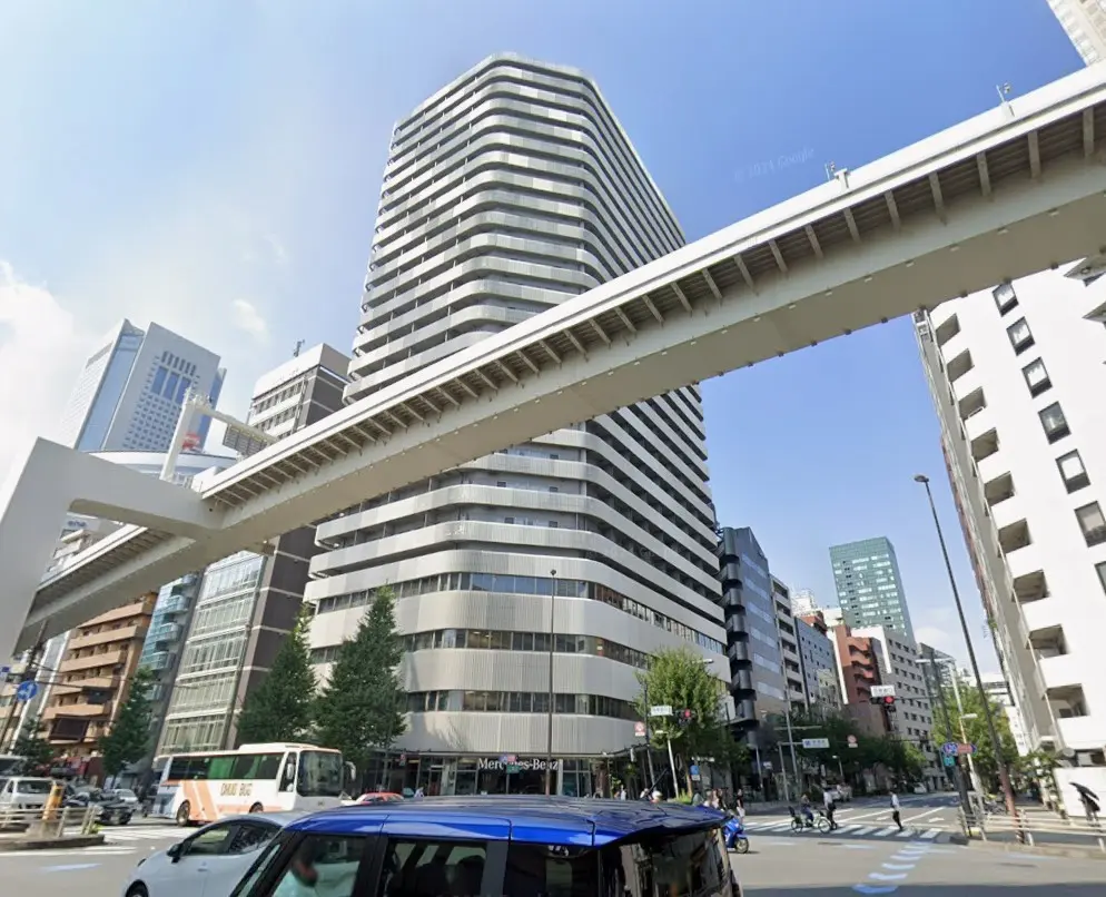 都市の交差点とオフィスビル、地上を走るバスと高架道路、晴れた日の風景