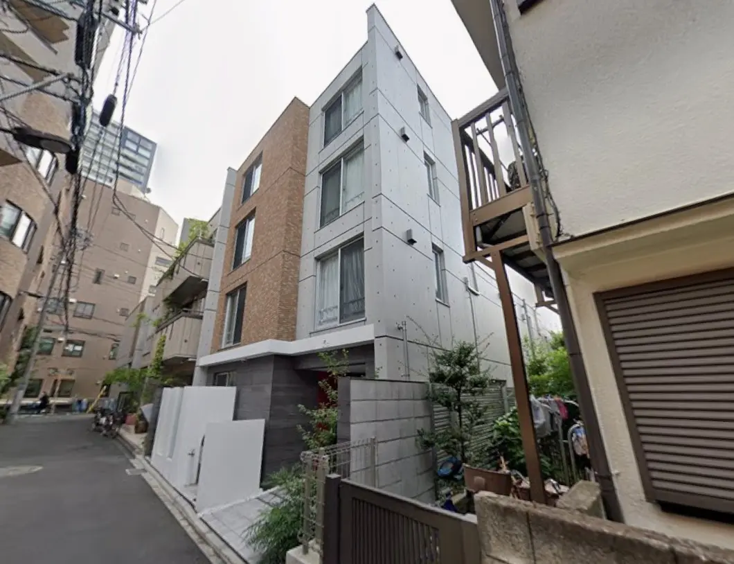 都市部のモダンなデザインの住宅街、コンクリートとレンガ造りの外観、緑植物と電線がある景観