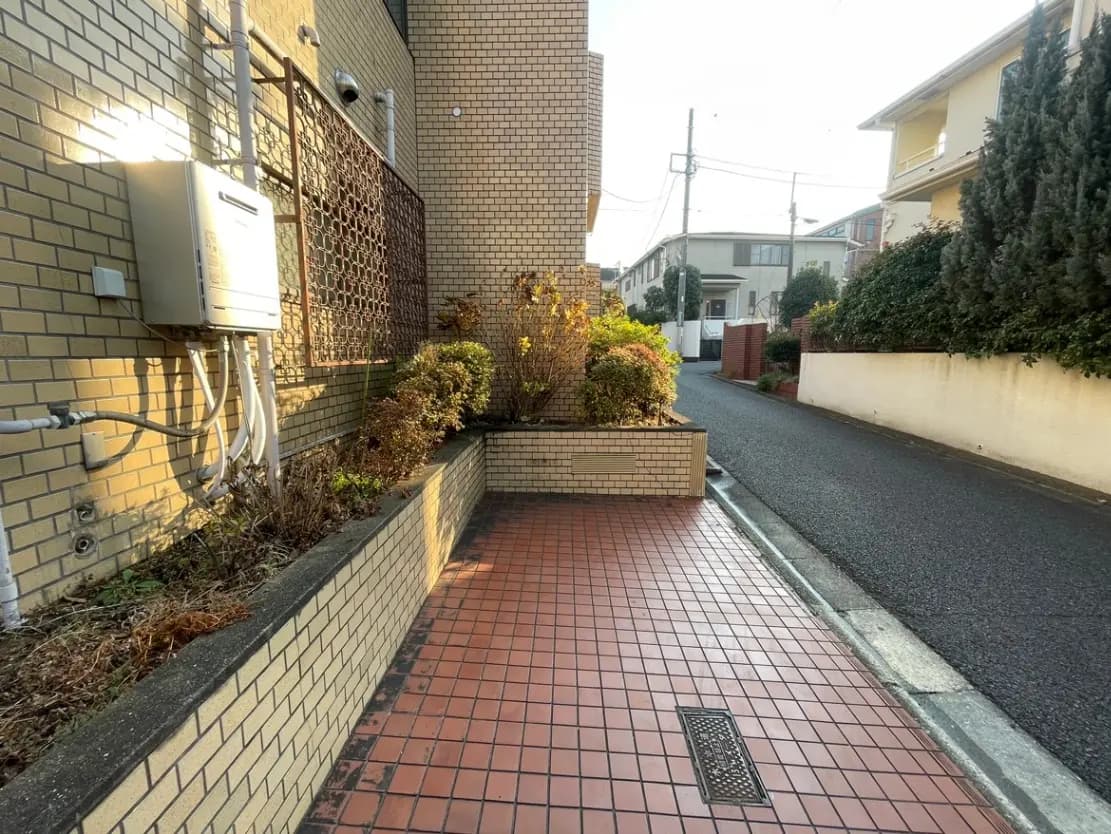 日本の住宅街の歩道と家の外壁、夕日が照明する落ち着いた雰囲気