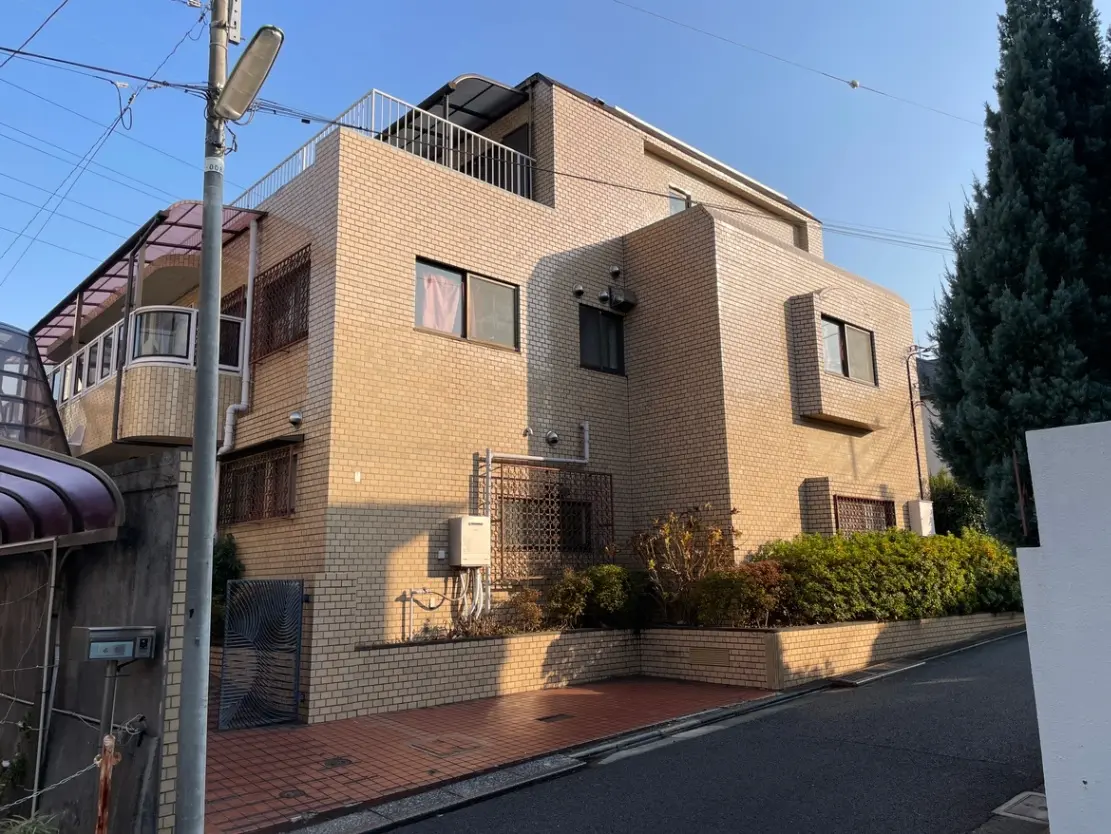 日本の住宅街にあるモダンなレンガ造りのアパートビル、晴れた日の屋外シーン