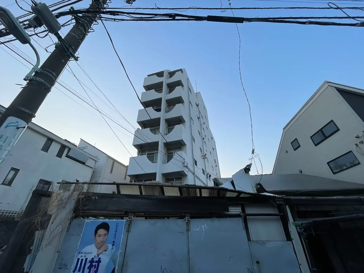 都市の電線と建物、青空の背景にあるモダンなマンション