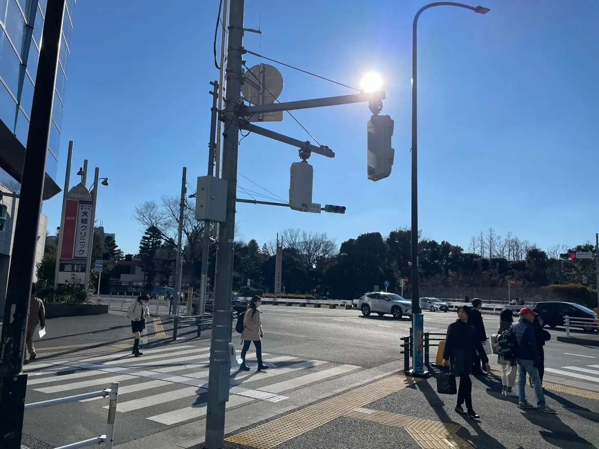 晴れた日の交差点、歩行者信号と横断歩道、街路灯と青空