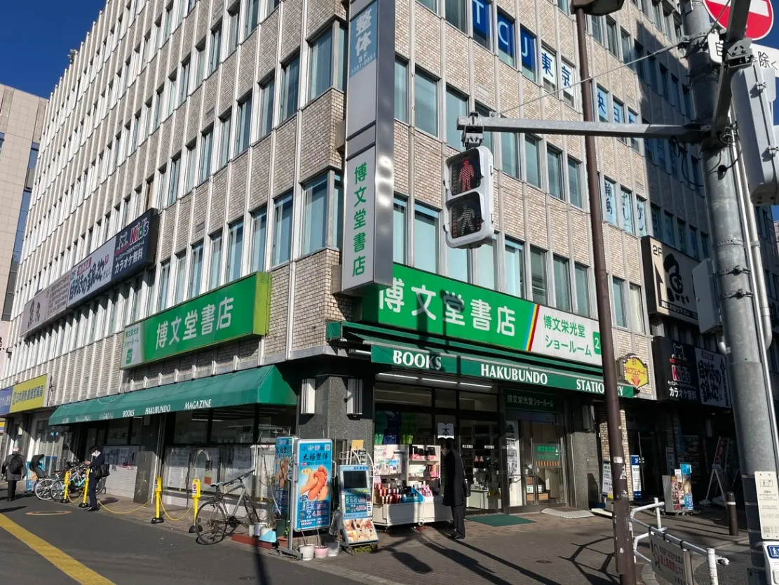 日本の書店が入る商業ビルの外観、晴れた日に撮影された交差点と人通り