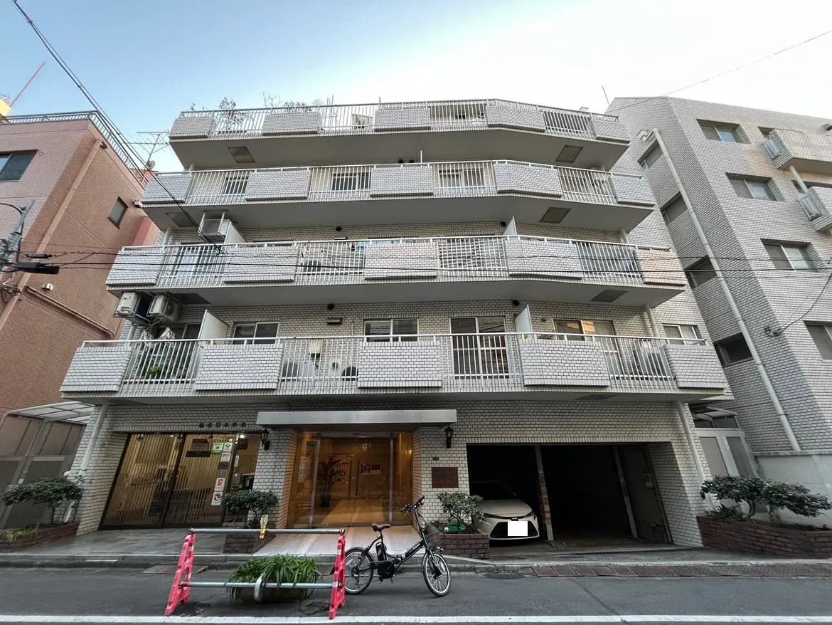 日本の都市部に位置するモダンなマンションの外観、ベランダ付き、駐車スペースあり