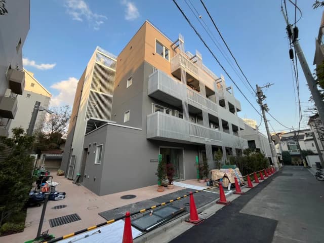 現代的な外観の都市型マンション、グレーのファサード、通り沿いに建つ、駐輪場付き