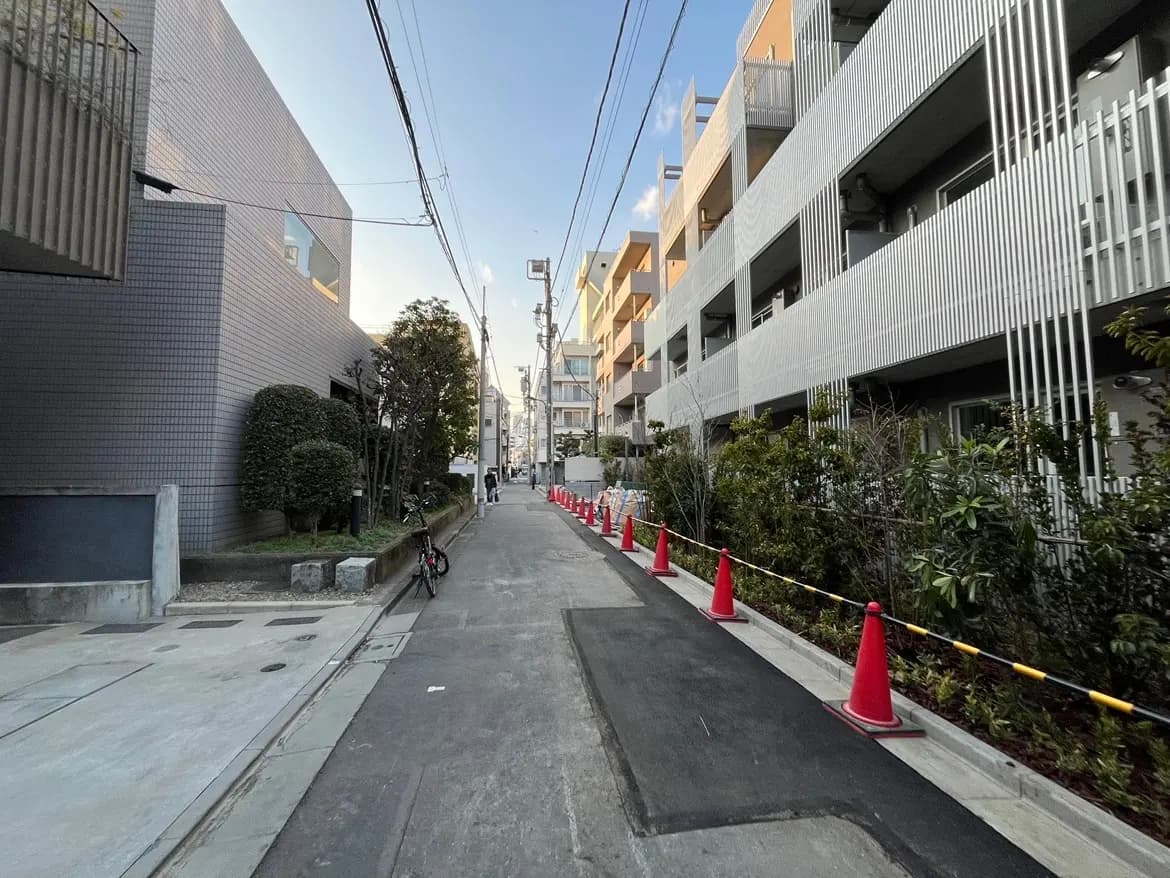 日本の住宅街の通り、モダンな建物とアパートメント、歩道横に整列した交通コーン