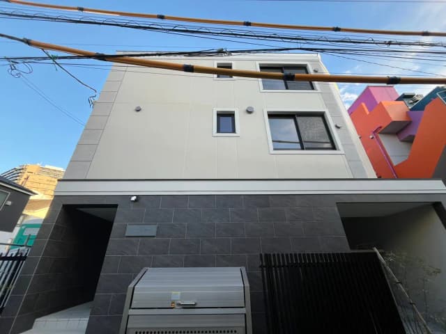 現代的な外観の都市型住宅、グレータイル張りのエントランスと白い壁
