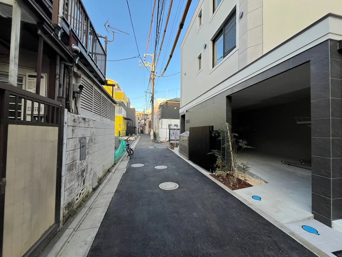 日本の住宅街の風景、狭い路地に面した家々と新築そうなモダンな建物、自転車が止まっている静かな通り