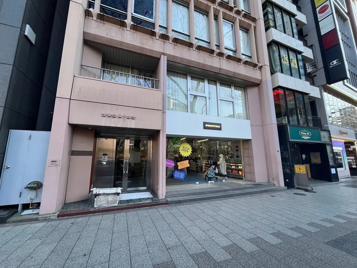 都市の商店街にある現代的な店舗の外観、平日の静かな歩道とショップのウィンドウディスプレイ