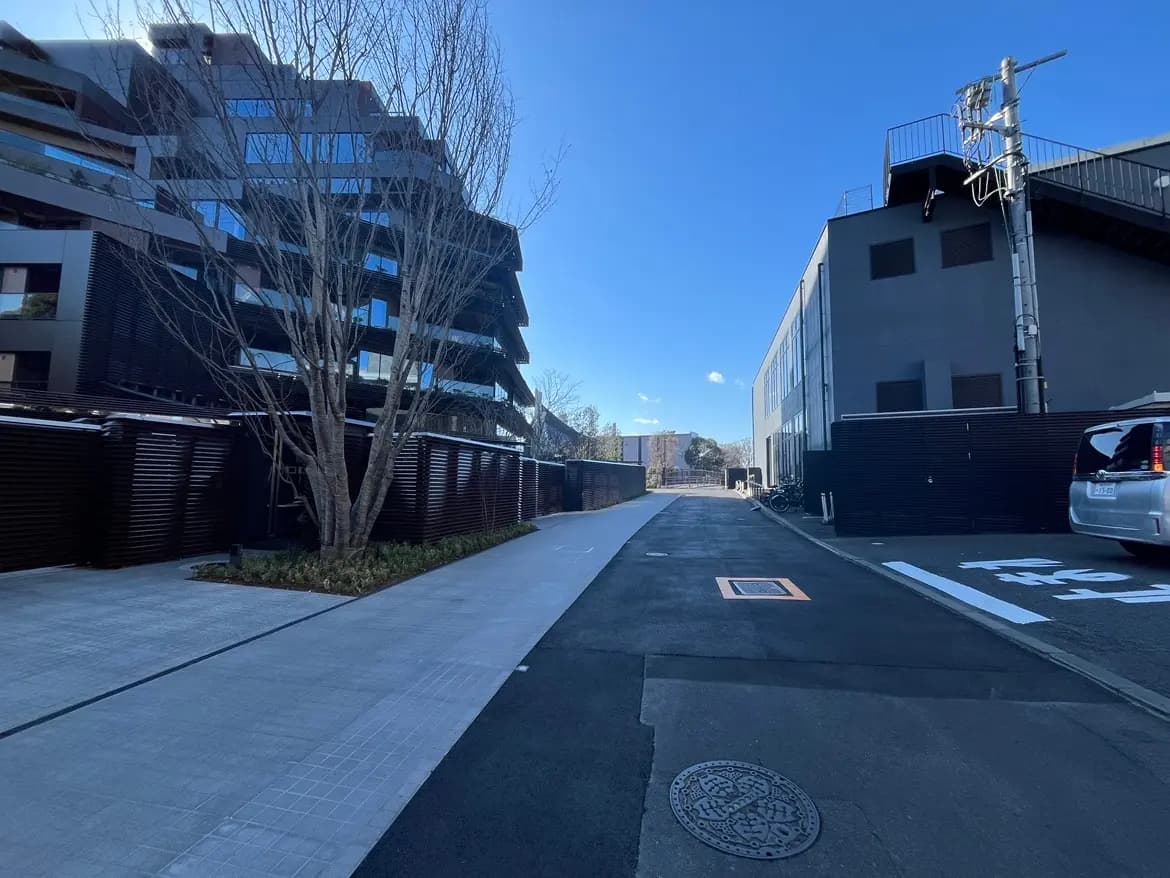 都市の住宅街にあるモダンな建築物のファサード、晴れた日の青空、整備された歩道