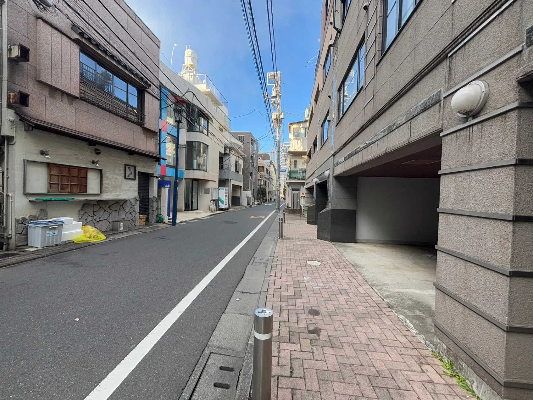 日本の閑静な住宅街の通り、街路に面したビルとアーケード、クリアな空と都市生活のシーン