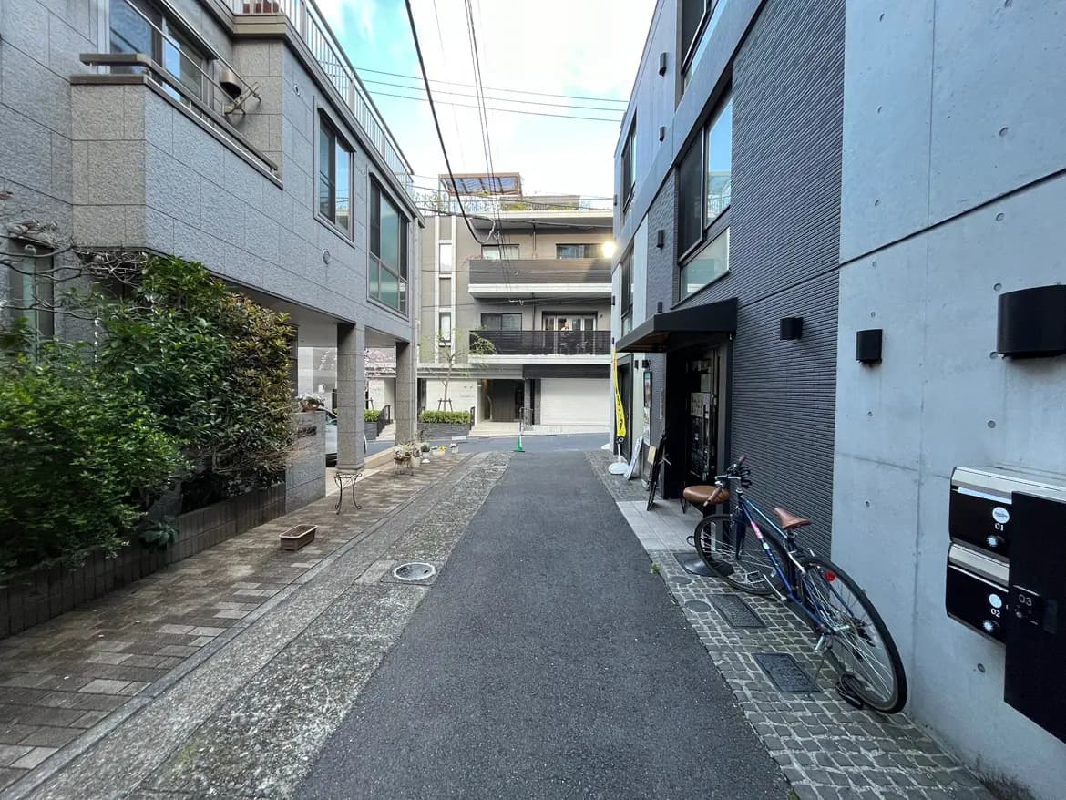 - 現代的なアパートメントエリアの風景、舗装された狭い路地とサイクリング用自転車、整然とした建物の外観と緑の植栽