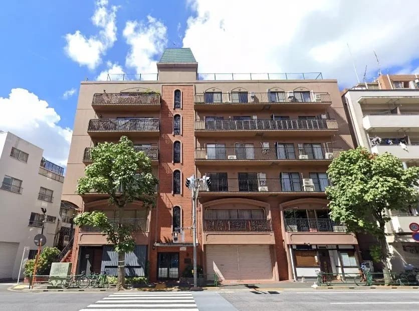 都会の通りに面したモダンなマンション、バルコニー付き、晴天の下での建物の外観