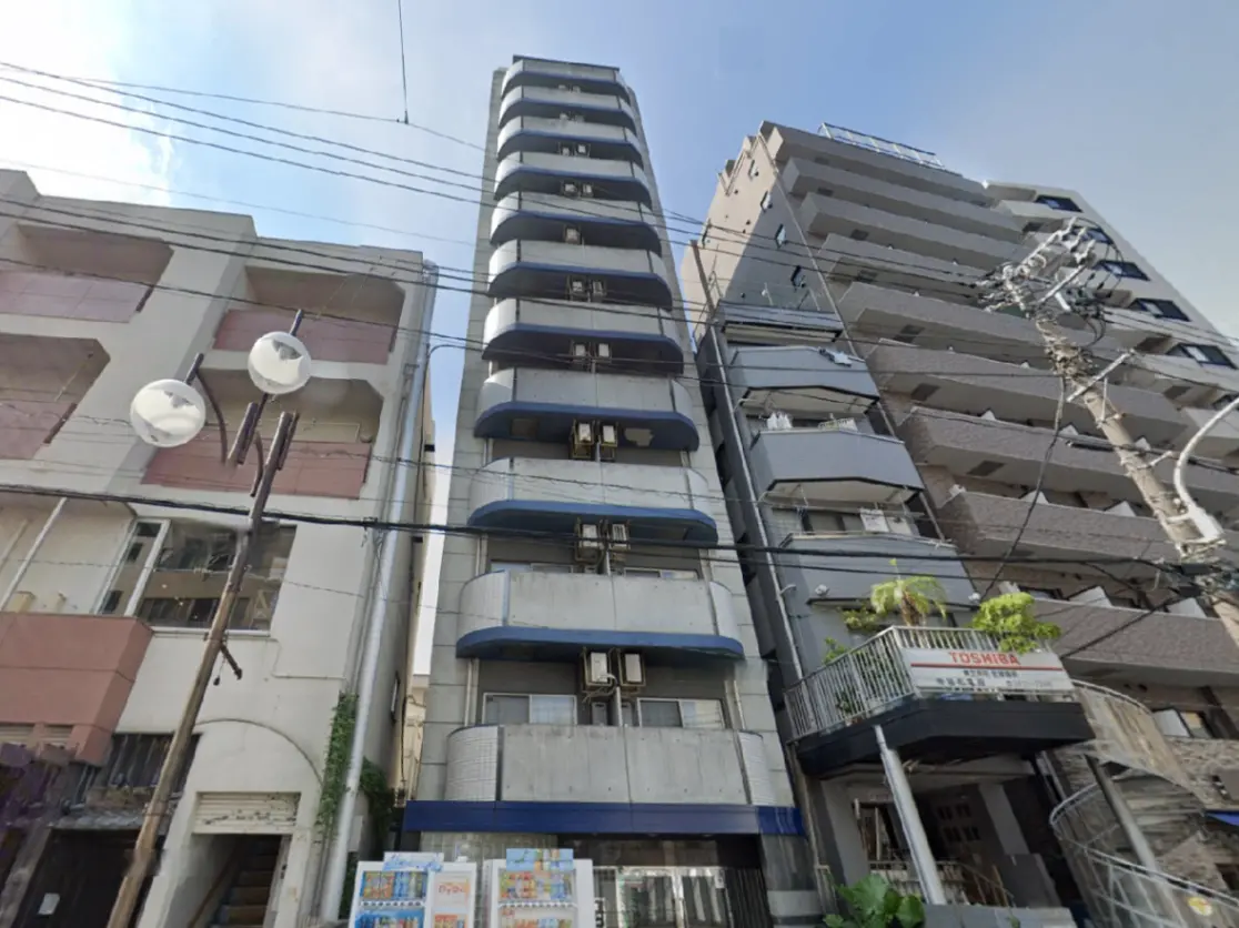 - 近代的な外観の高層マンション、隣接する建物との対比、外壁に設置されたエアコンとバルコニーが特徴の一Kタイプのアパートメント