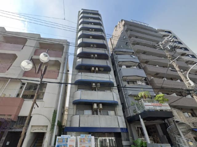 - 近代的な外観の高層マンション、隣接する建物との対比、外壁に設置されたエアコンとバルコニーが特徴の一Kタイプのアパートメント