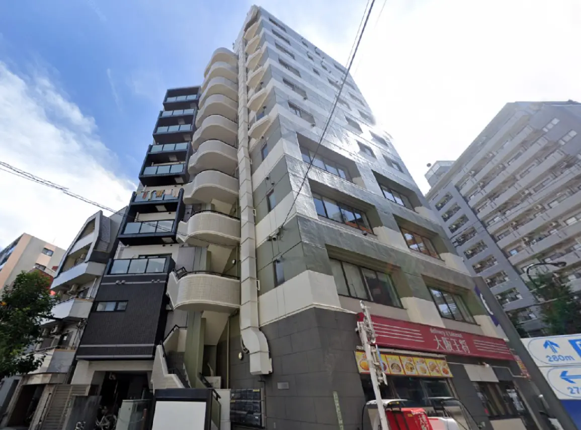 - 現代的なデザインのマンション外観、バルコニー付きの高層ビルと周囲の風景、青空が広がる背景