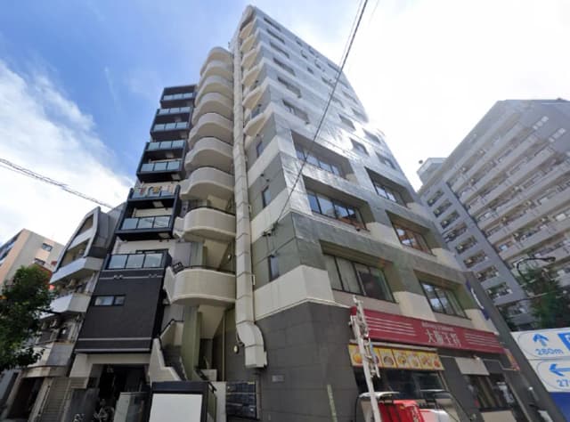 - 現代的なデザインのマンション外観、バルコニー付きの高層ビルと周囲の風景、青空が広がる背景