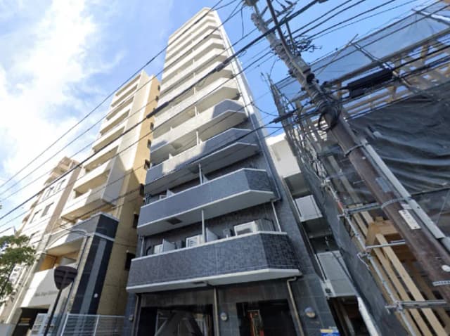 - 近代的な高層マンション、特徴的なバルコニーと外壁デザイン、青い空を背景にした建物の外観