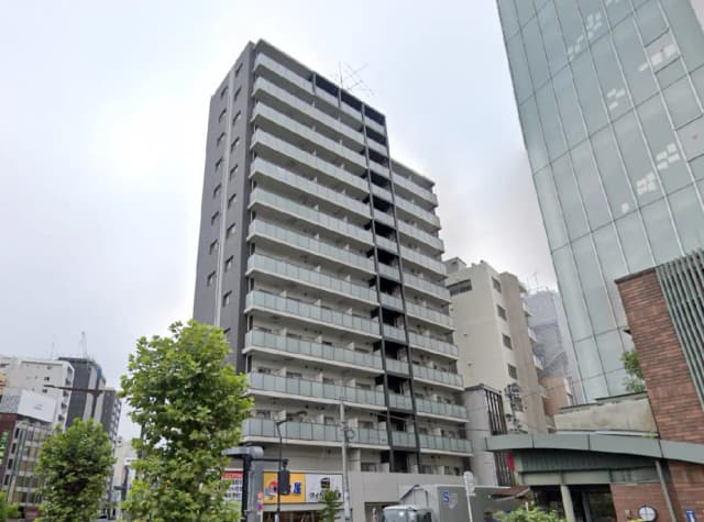 - モダンなデザインの集合住宅、バルコニー付きの階層構造、周囲に都市景観が広がる外観