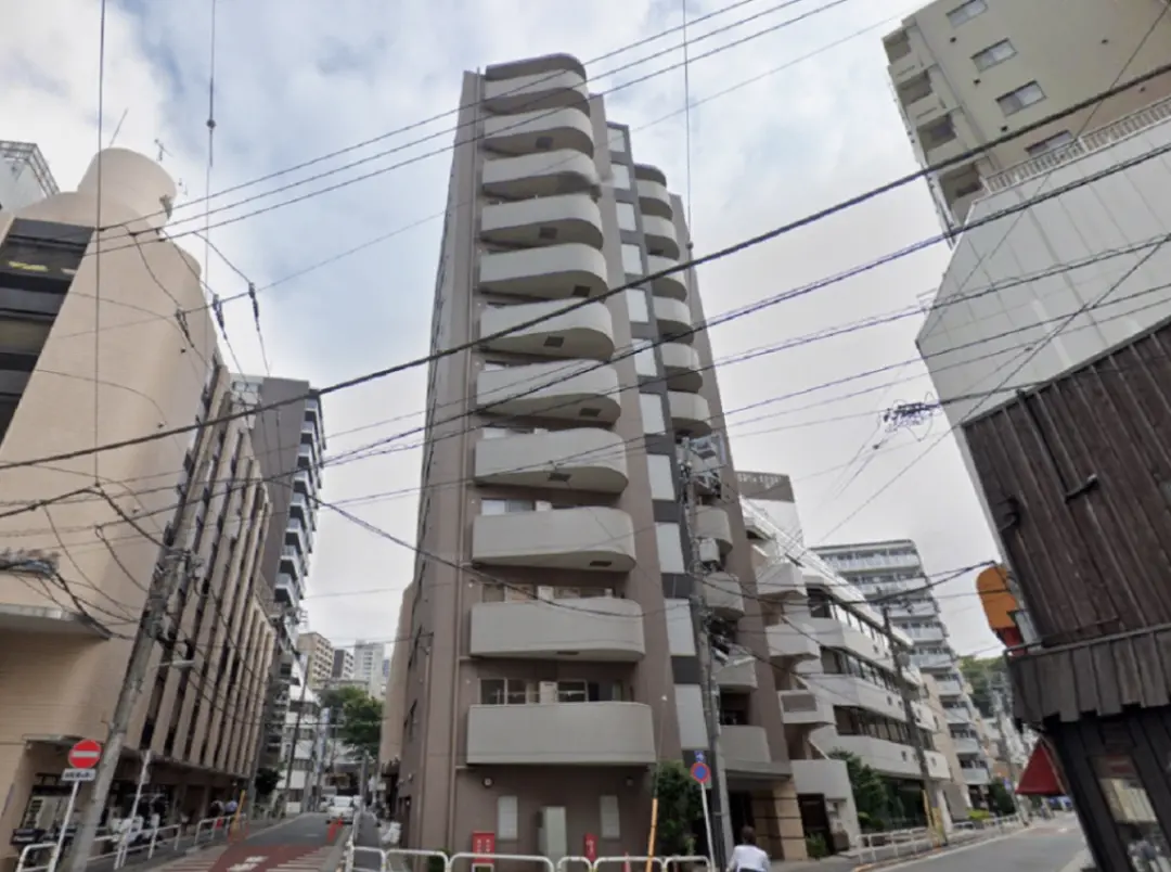 - 現代的なデザインのマンション、バルコニーがついた外観と都市の街並み、複数の建物が立ち並ぶ風景