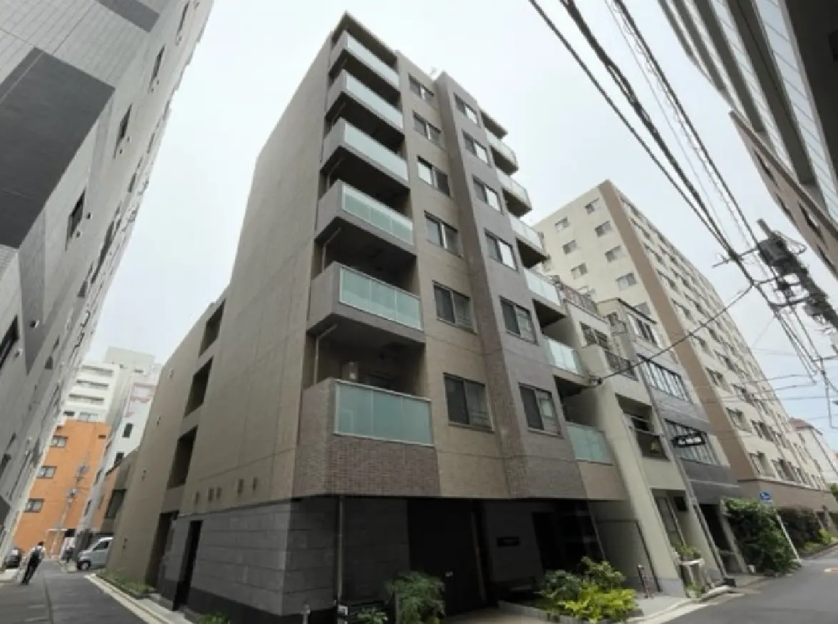 - 都市部にある現代的な外観のマンション、バルコニーや窓が多く、周囲には他の建物が立ち並ぶ景観
