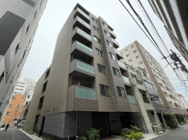 - 都市部にある現代的な外観のマンション、バルコニーや窓が多く、周囲には他の建物が立ち並ぶ景観