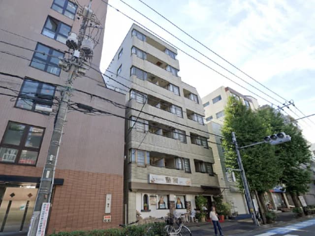 - 都市の風景に立つアパートメントビル、カフェと緑豊かな歩道が広がる街角の様子