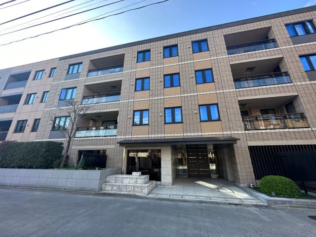 現代的な外観のマンション、明るい日差しと広いエントランス