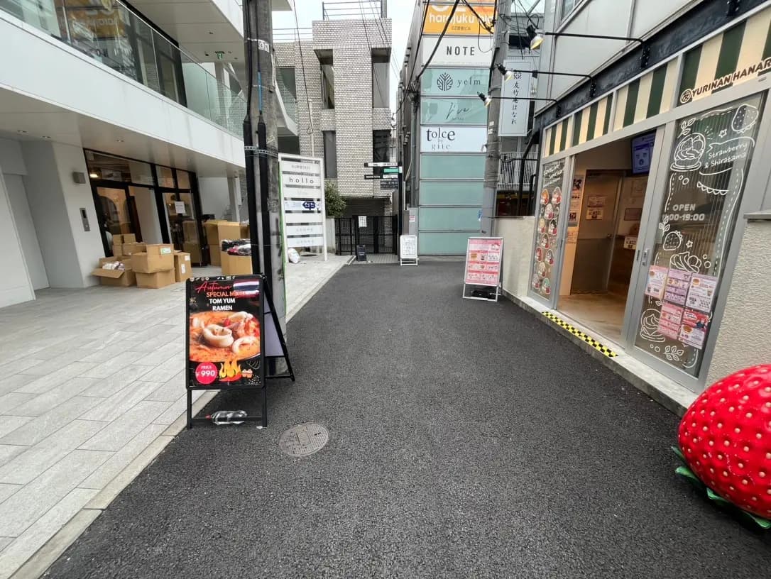 都市の路地にある飲食店の外観、看板メニューのラーメン宣伝看板が目立つストリートビュー