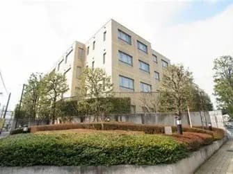 都市部に位置する現代的なマンションの外観、緑豊かな庭園とクリーンなファサード