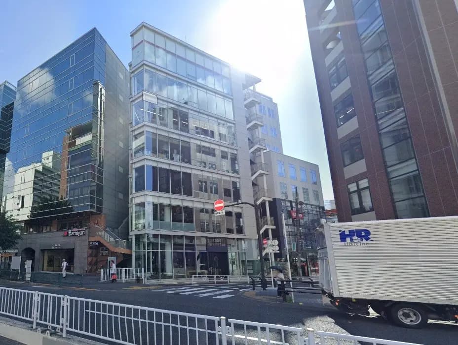 都市部に位置する現代的なオフィスビル群、晴れた日の青空、道路と歩行者