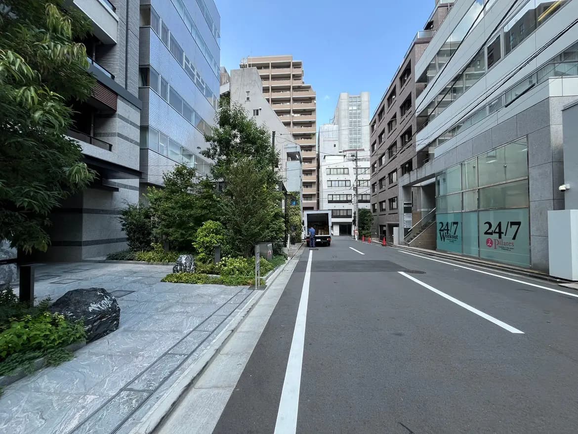 - 都会的な街並みに囲まれた緑豊かな歩道、近代的なビルと自然が調和した景観
