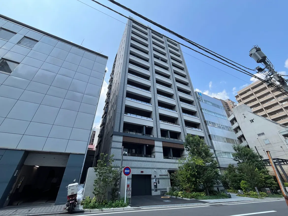 - 都市型の高層マンション、近代的な外観と緑豊かな周囲、晴れた空を背景にした写真