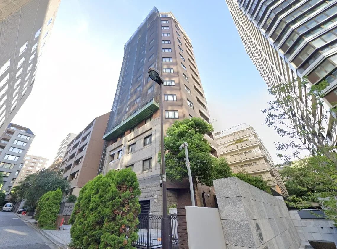 都市環境に佇む高層マンション、清潔感のある建物ファサード、緑豊かな通り