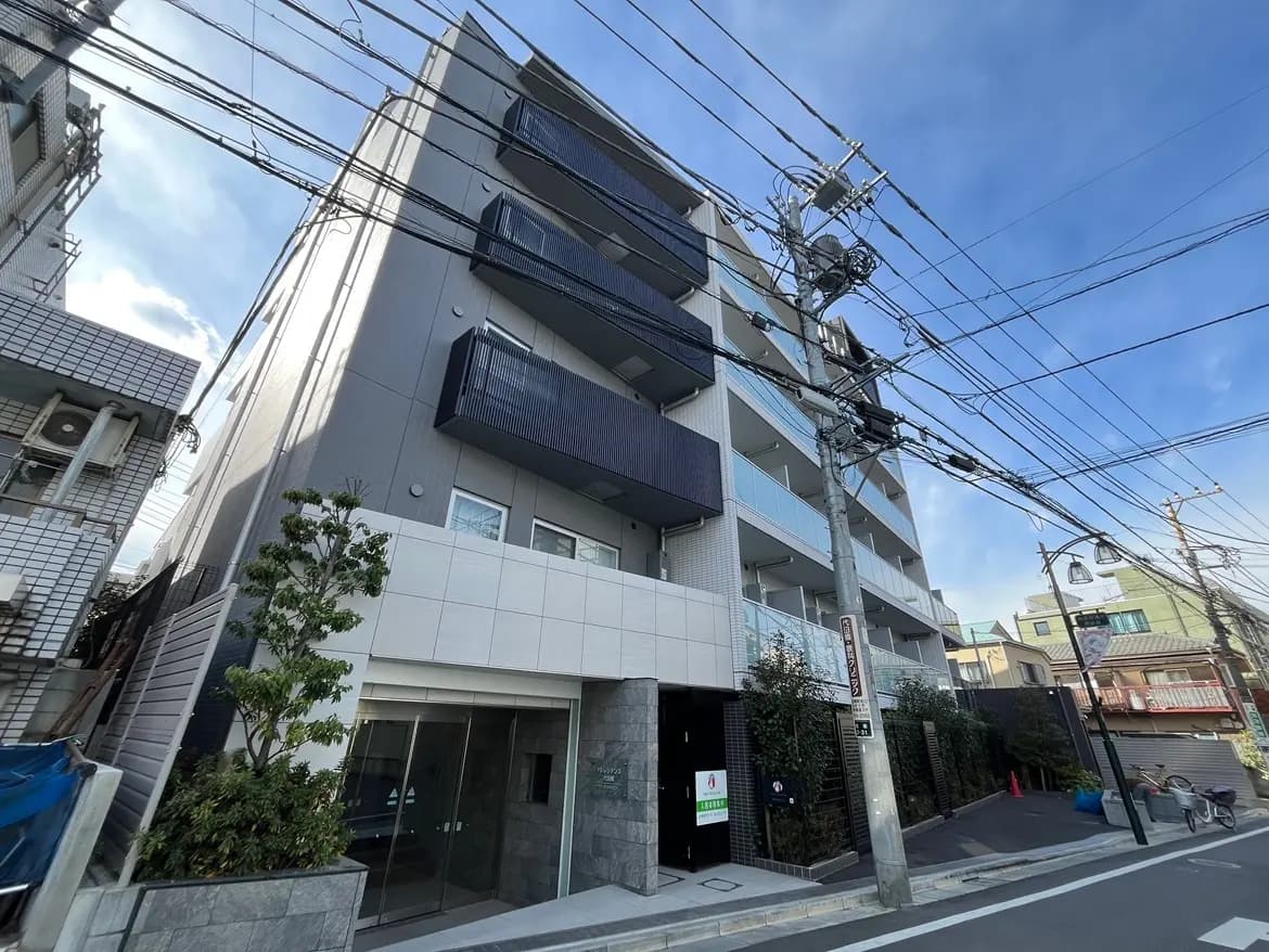 現代的なデザインの都市型アパート、グレーファサードとバルコニー、通り沿いに立つ