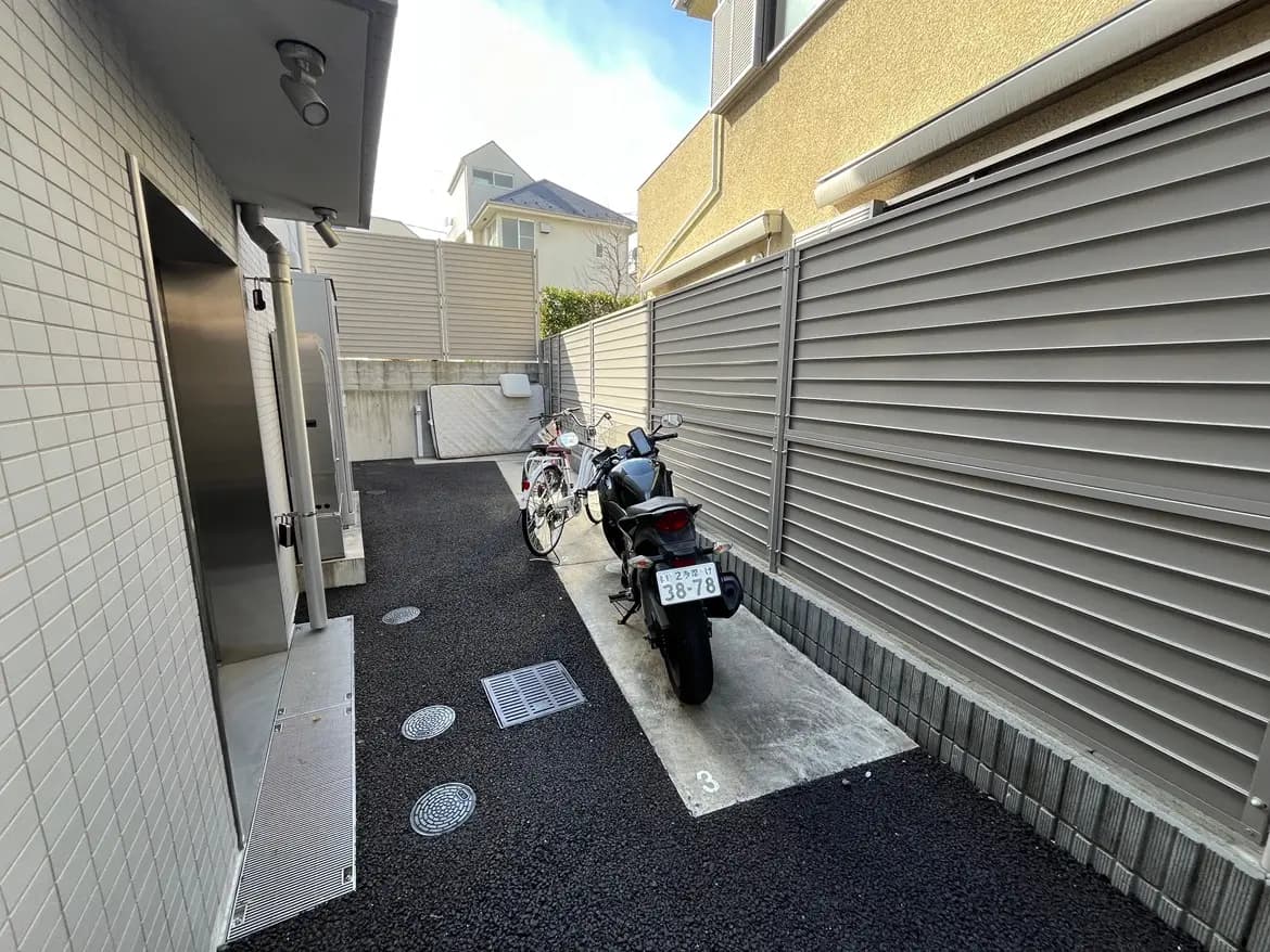 駐輪スペースがある都市のアパートメント、清潔な舗装された路地、自転車とバイクが停まっている