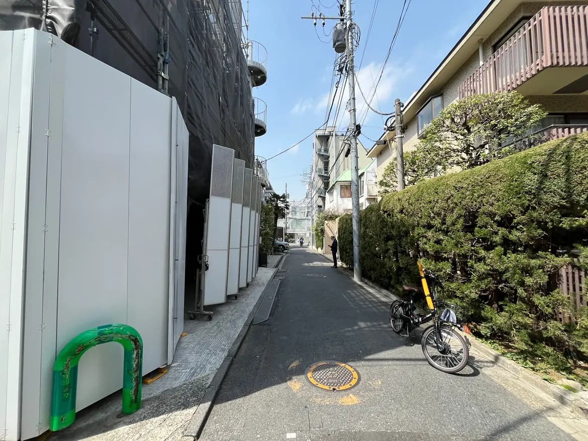 日本の住宅街の狭い道路、自転車が駐輪されており、晴れた日の都市の景色