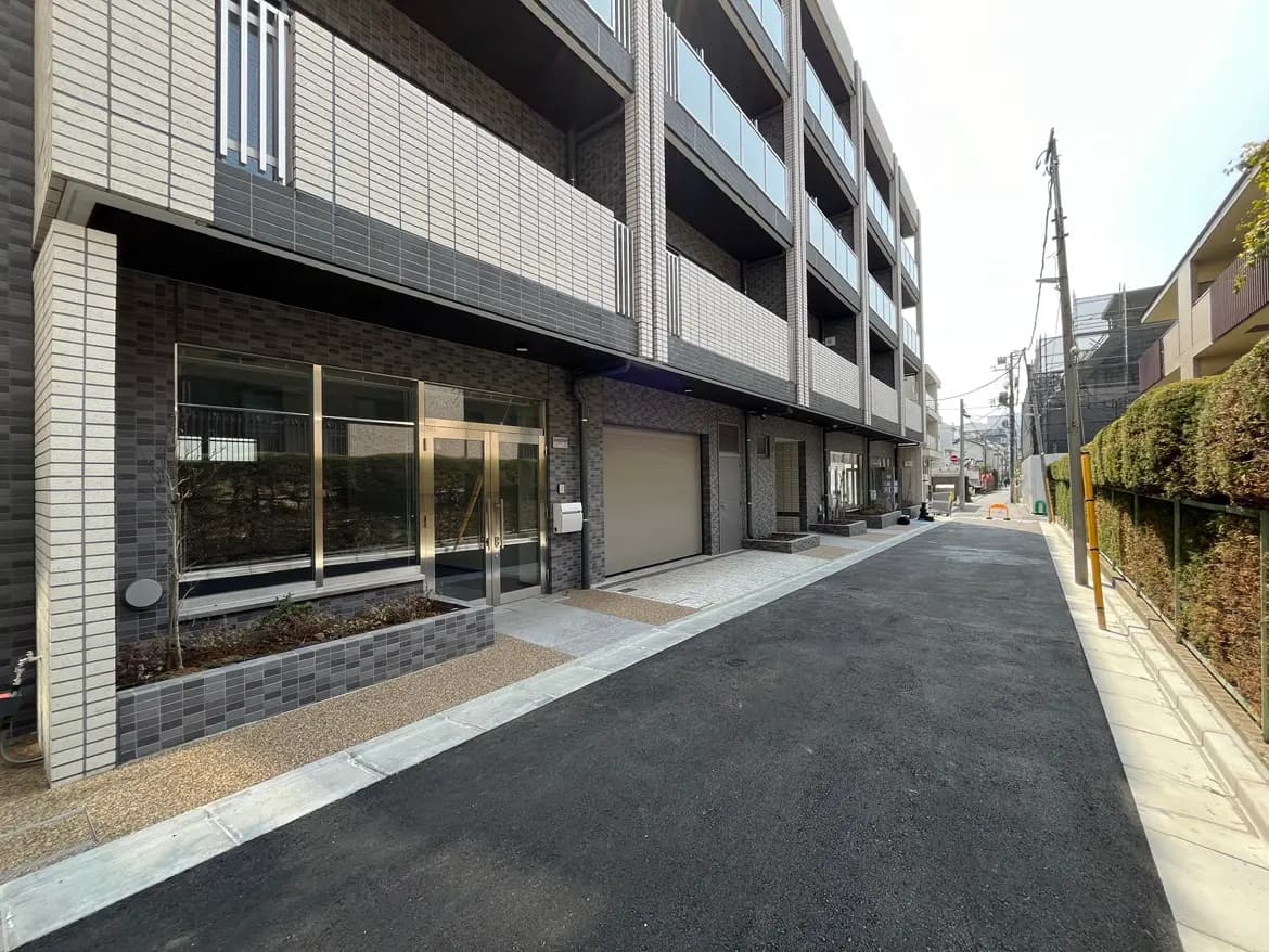 現代的な外観のアパートビルと整備されたアクセス道路、都市型住宅の快適な入り口