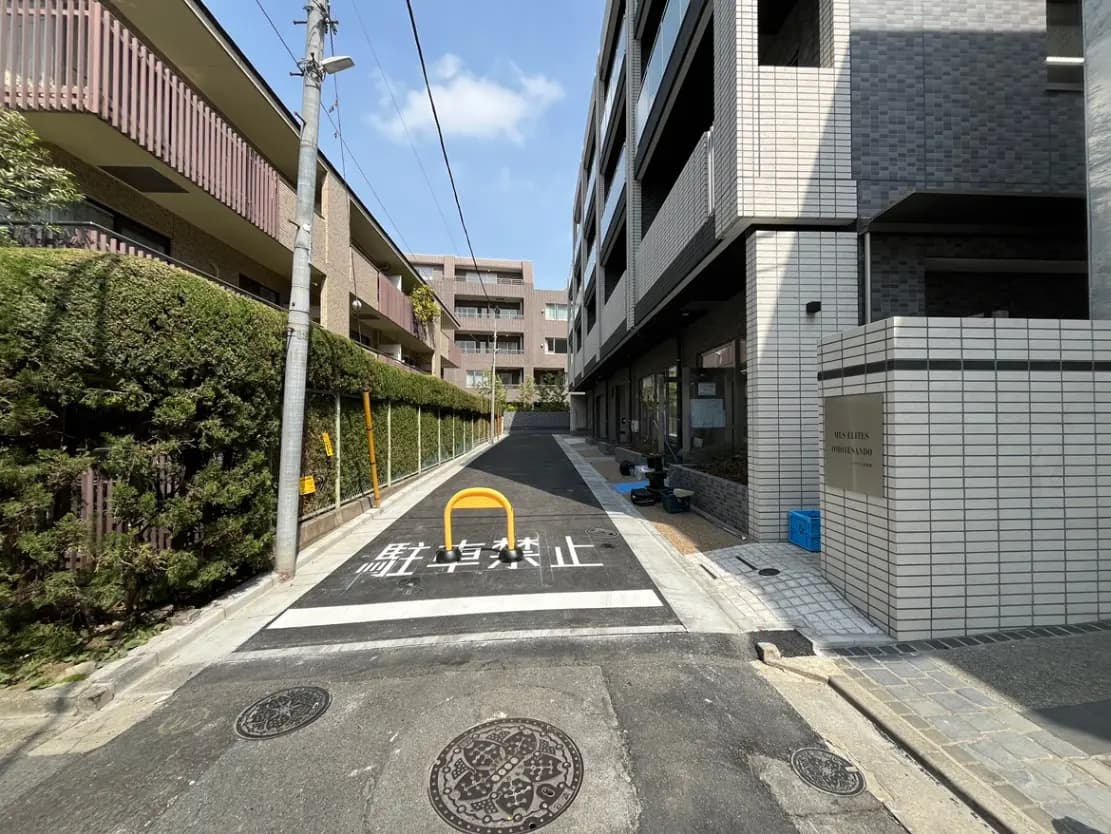 日本の住宅街の歩道と道路、自転車駐輪禁止の標識とマンションエントランス