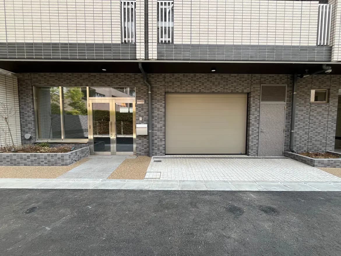 モダンな外観の一戸建て住宅、駐車スペース付きの玄関とガレージ