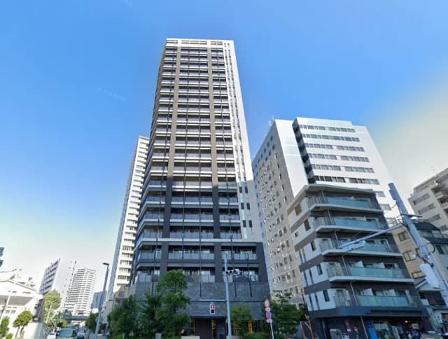 現代的な都市の高層マンション、晴天の下でのクリアな青空、周囲には中層ビル