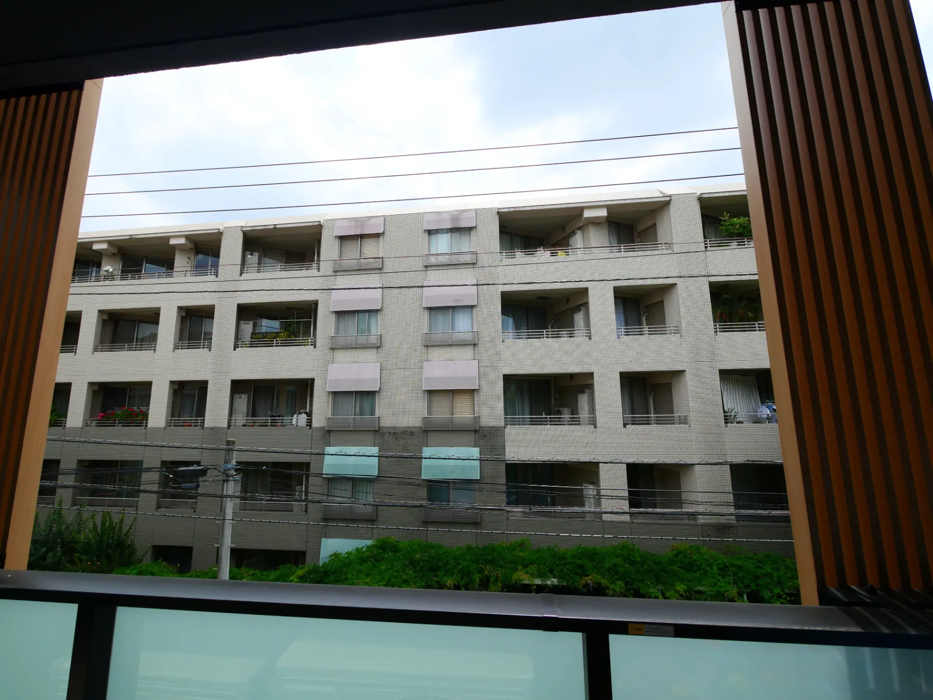 窓から見える都市のアパートビル、ベランダ付きの部屋が並ぶ外観
