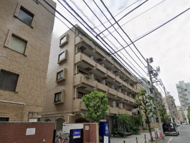 - モダンな外観の住宅、複数階建てのアパート、周囲に緑豊かな植栽と電線が見える都市の風景