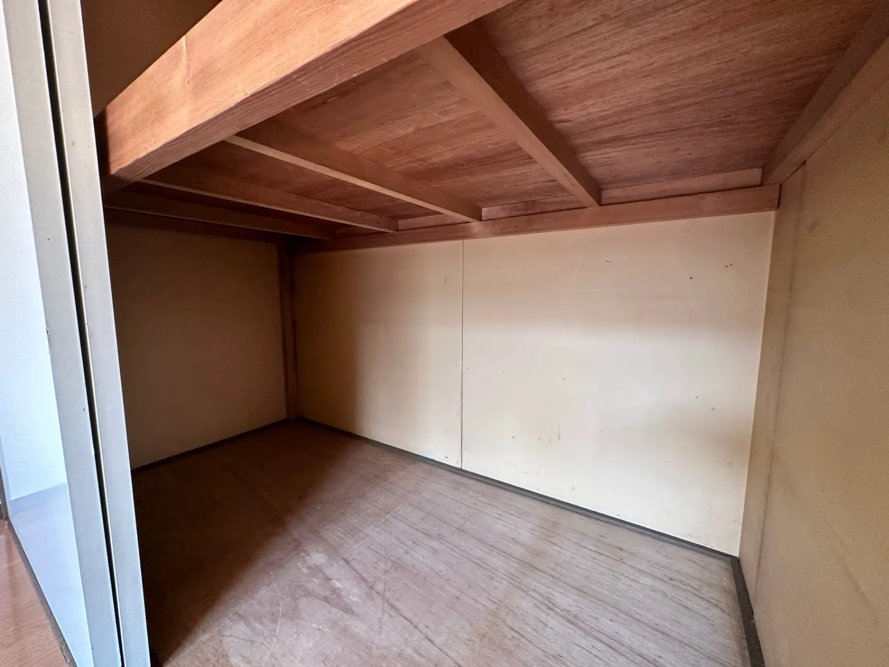 空の部屋と木製の床、白い壁と木の梁、シンプルなインテリアデザイン