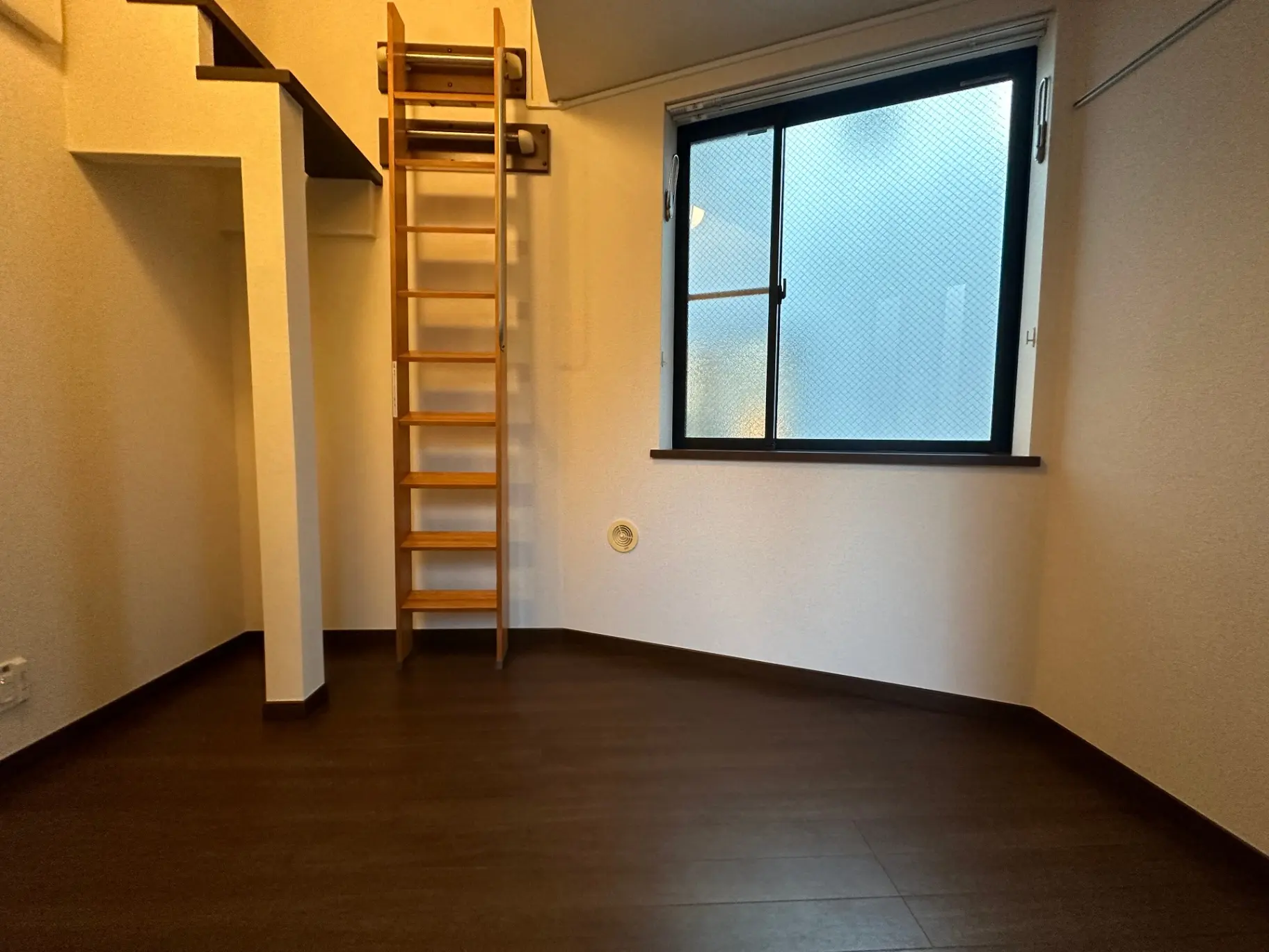 ロフト付きのコンパクトなお部屋、木製のはしごと暖色系の床